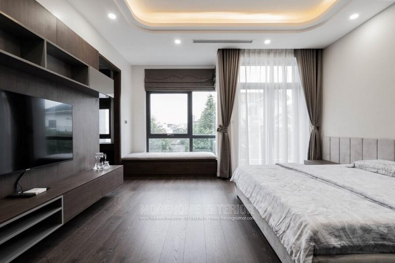 Kệ tivi được sử dụng để trang trí phòng ngủ biệt thự khi kết hợp với vách ốp tường.
